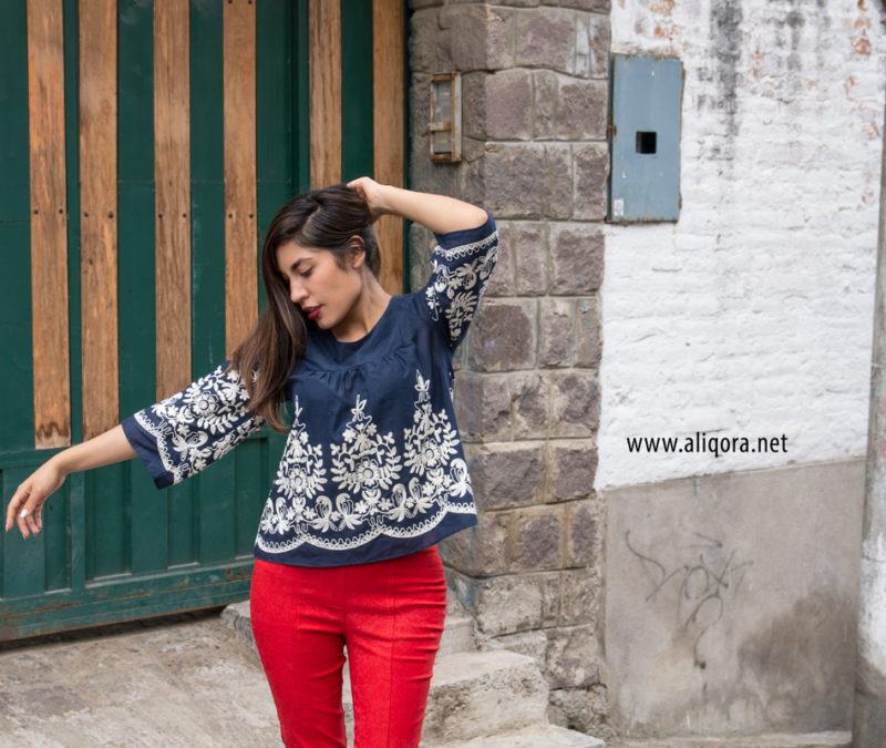 Blusa azul con tejido de flores blanco y pantalón tubo naranja